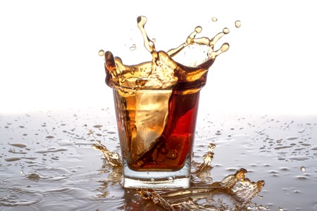 Splashing in glass with soda, ice cubes, white backgroundの写真素材