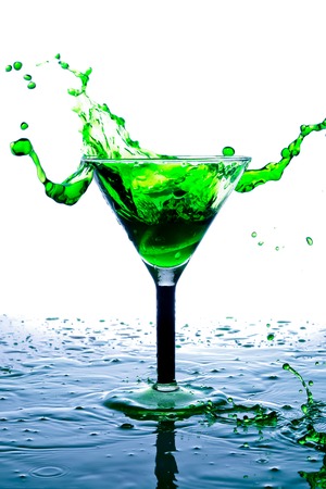 splash in a glass with green drink on a white backgroundの写真素材