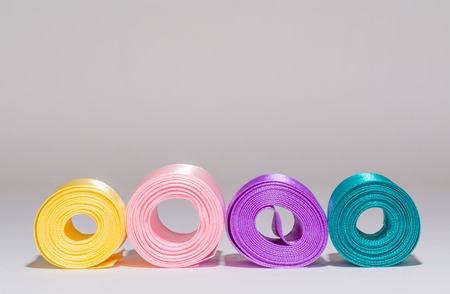 Colored coils of silk satin ribbons on the gray backgroundの写真素材