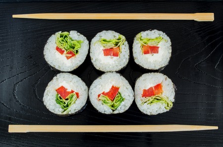Sushi on a black wooden tray with chopsticks backgroundの写真素材