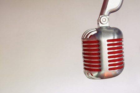 silver vintage microphone with red membrane ?lose up on a grey vintage background