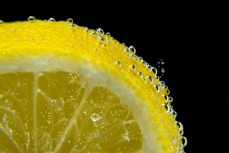 Lemon water bubbles dark black background close-up macroの写真素材