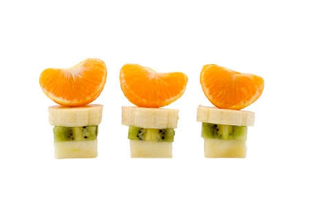 three columns of cutting apple kiwi banana and tangerine on a white backgroundの写真素材
