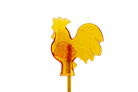 candy on a stick in the form of a rooster isolated on a white backgroundの写真素材