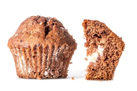 Cut a piece of chocolate cake with a close muffins closeup crumbs near isolated on white background