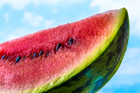 watermelon slice closeup on blue sky backgroundの写真素材