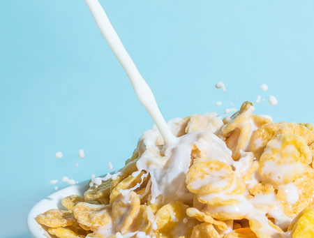 Milk pouring into a bowl with a glass of milk. Milk splash on a white background.の写真素材