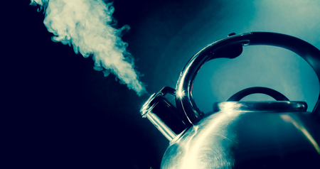 Kettle whistling, boiling kettle, steam, isolated on a black backgroundの写真素材