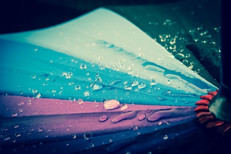 Multi-colored colorful umbrella with all colors of the rainbow with raindrops. Vintage, grunge, old, retro style photo.の写真素材