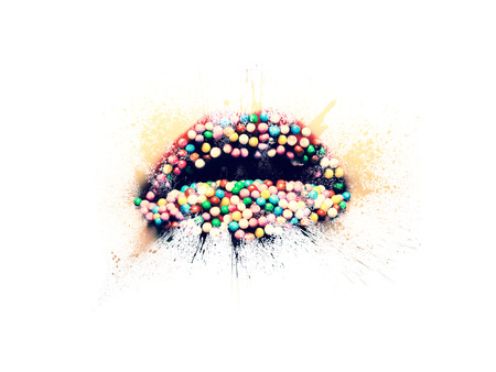 Conceptual photo of a female lips with red lipstick and candies close-up in the form of splashes, explosion paint isolated on a white background. Female lips close-up with spray paint around.の写真素材