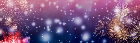 Colorful fireworks background with falling snow at night and with free space for text