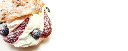 Fruit cake with american blueberries and strawberries close-up isolated on a white background with...