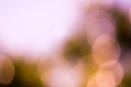 Summer abstract bokeh background in soft warm pastel orange and pink tones with sun rays. Beautiful...