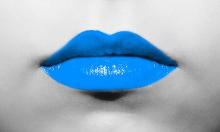 Female lips close-up with light soft blue lipstick bright juicy color on a background of black and white face.の写真素材