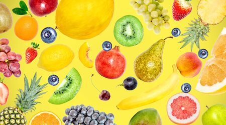 Creative photo of many different exotic tropical bright fruits on a yellow summer background. View from above. Bright summer fruit pattern.の写真素材
