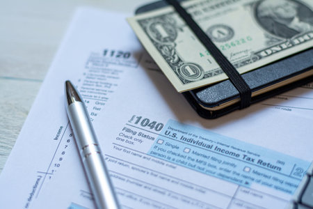 U.S. individual and corporation income tax return close-up next to a calculator, dollars, money, a...