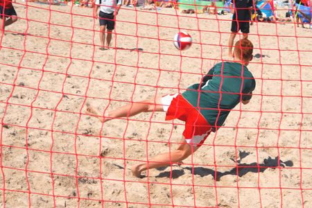 Young adults playing football at the beachの写真素材