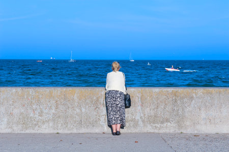 GDYNIA, POLAND - SEPTEMBER 14: A woman at the sea side on September 14, 2014 in Gdyniaのeditorial素材
