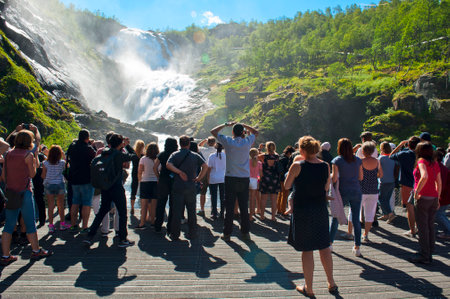 MYRDAL-FLAM, NORWAY - JULY 16, 2018: A stop at the Kjosfossen waterfall and a mysterious woman in a long red dress dancing on the Flam Railway (Flamsbana) train on the tour: Norway in a Nutshellのeditorial素材