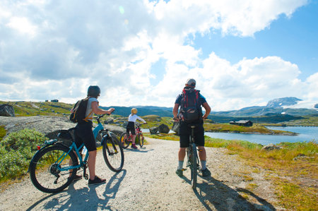 FINSE, NORWAY - JULY 28, 2019: Tourists biking in Finse