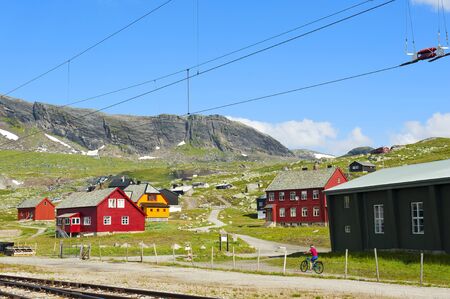 Tourist biking and colorful houses in Finse, Norway, on July 28 2019