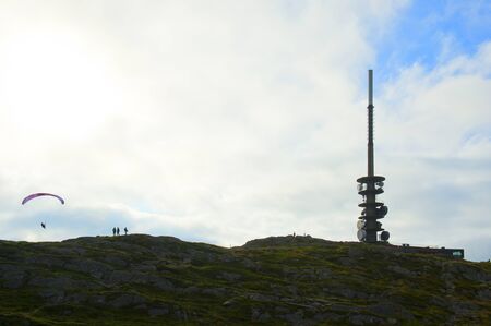 Beautiful view with the Mount Ulriken, paraglider and tourists in Bergen, Norway, on August 4 2019の写真素材