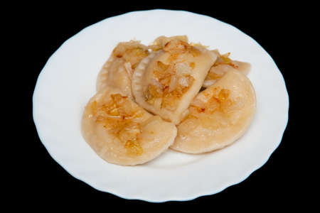 Dumplings on white plate on black background