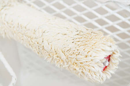 Close up of paint roller with white paint