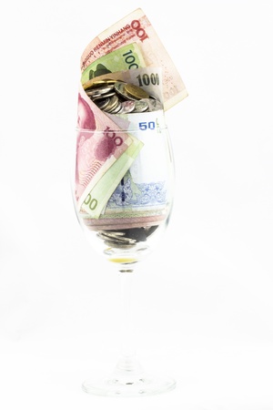 bills and coins in a wine glassの写真素材