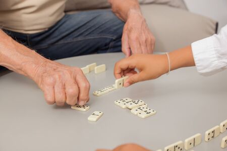 Grandfather and grandson playing game Dominoes.の写真素材