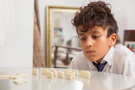 Boy playing game Dominoes.の写真素材