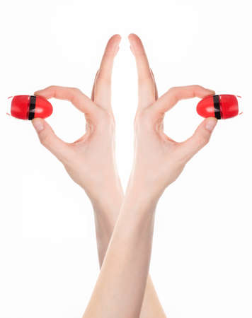 A woman's hand holding a small pot of red nail polish.の写真素材