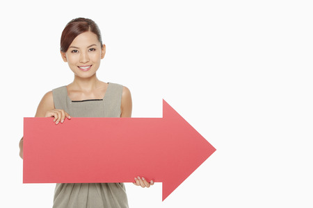 Businesswoman holding up a red arrow