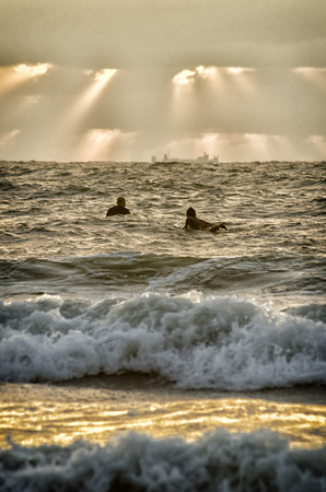 shaft of light and surferの写真素材