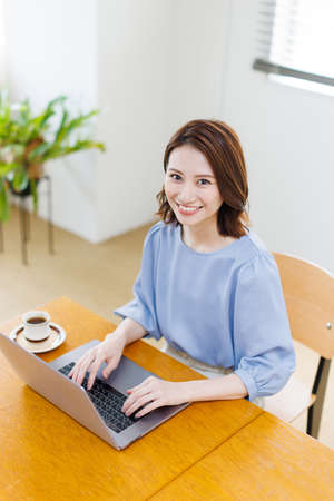 Young Asian woman using a laptop and smilingの写真素材