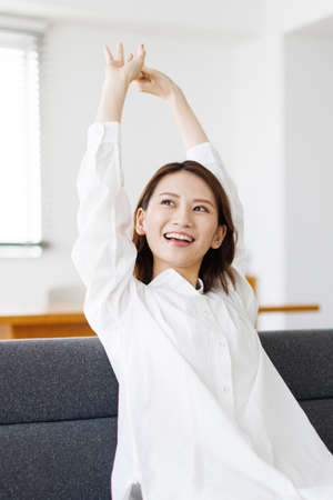 Young Asian woman stretching her armsの写真素材