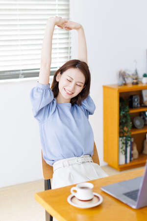 Young Asian woman stretching her armsの写真素材