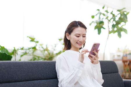 Young Asian woman using a mobile phoneの写真素材