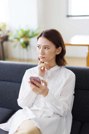 Young Asian woman using a mobile phoneの写真素材