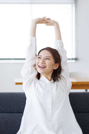 Young Asian woman stretching her armsの写真素材