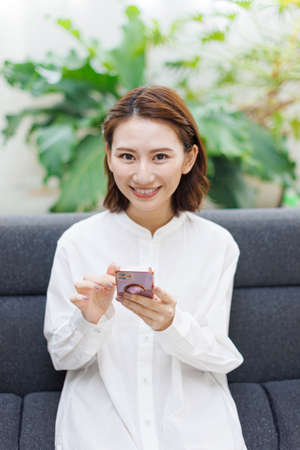 Young Asian woman using a mobile phoneの写真素材