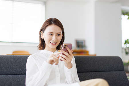 Young Asian woman using a mobile phoneの写真素材