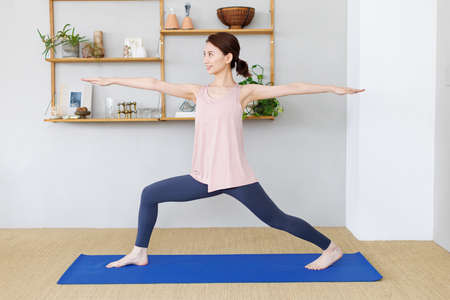 Young Asian woman practicing yoga at homeの写真素材