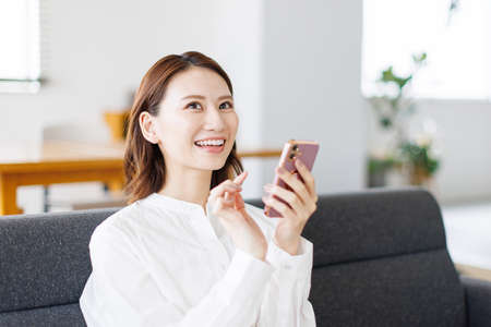 Young Asian woman using a mobile phoneの写真素材