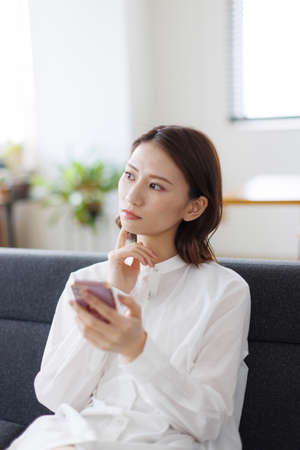 Young Asian woman using a mobile phoneの写真素材