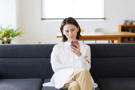 Young Asian woman using a mobile phoneの写真素材