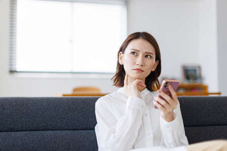 Young Asian woman using a mobile phoneの写真素材
