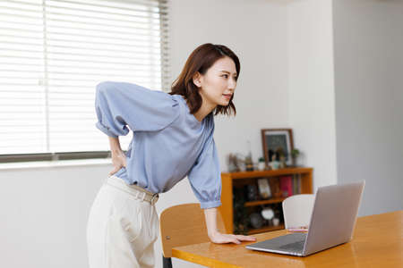 Young Asian woman having waist painの写真素材
