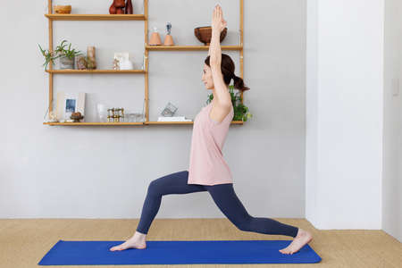 Young Asian woman practicing yoga at homeの写真素材