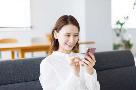 Young Asian woman using a mobile phoneの写真素材